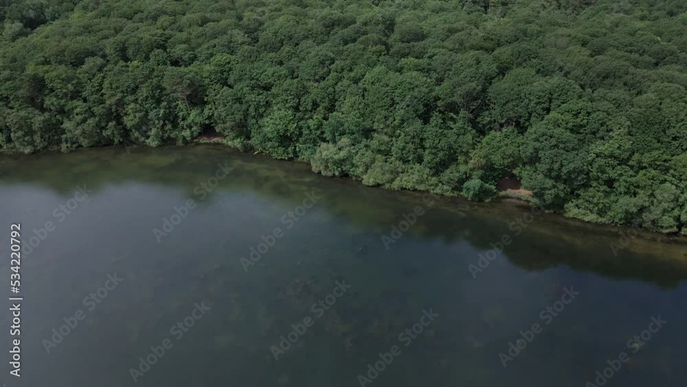 Trémelin lake and surrounding forest, Brittany in France. Aerial forward Trémelin lake and surrounding forest, Brittany in France. Aerial forward
