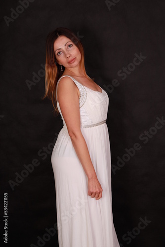 Beautiful woman in white dress on black background