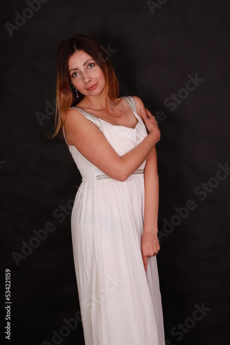 Beautiful woman in white dress on black background