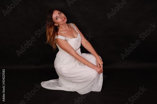 Beautiful woman in white dress on black background