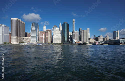 View from a boat to East River with Manhattan and Brooklyn bridges landmark and other iconic buildings from New York City during a beautiful sunny day. © Dragoș Asaftei