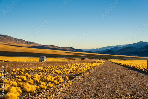 Campervan in a black dirty road with yellow grass in La Puna Argentina photo