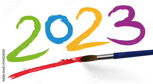 Concept artistique pour une carte de voeux, avec l’année 2023 écrite de différente couleurs avec un pinceau, sur un fond blanc.