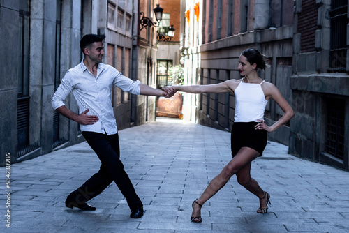 Tango dancing couple. Boy in a suit and shirt, girl in shorts and a t-shirt. dance, street, argentinian
