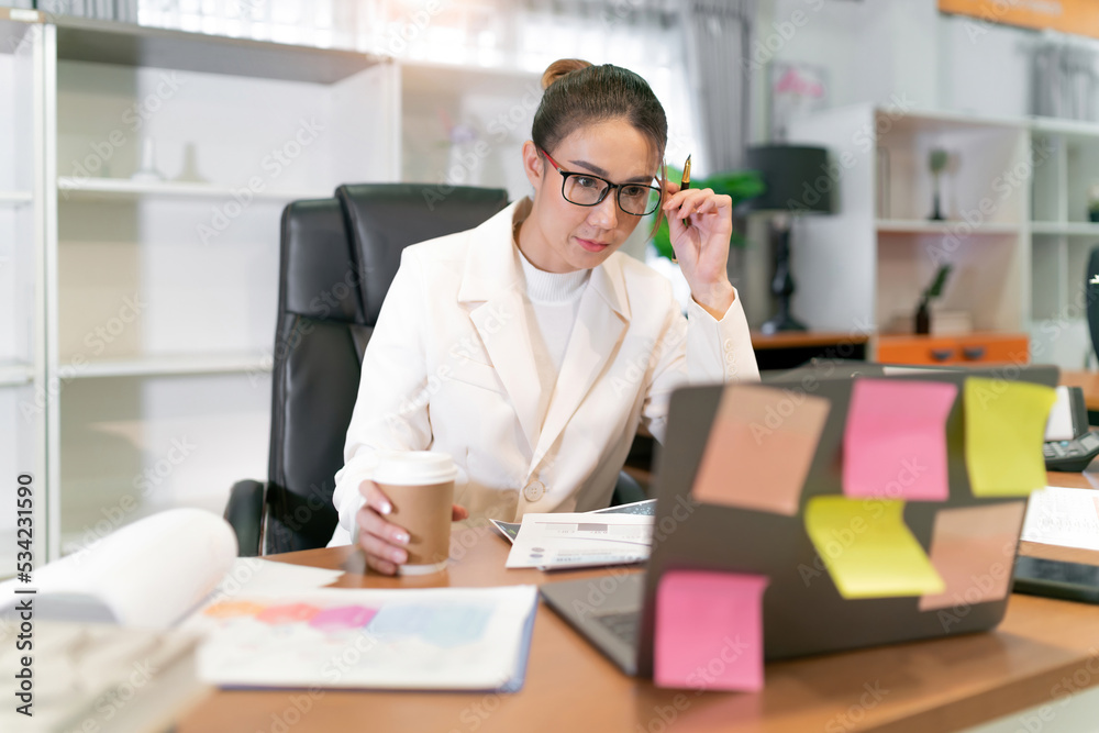 focus business beautiful asian woman work. serious thinking female office online worker holding coffee cup video call with meeting team. confident occupation office woman plan business and hot drink focus business beautiful asian woman work. serious thinking female office online worker holding coffee cup video call with meeting team. confident occupation office woman plan business and hot drink