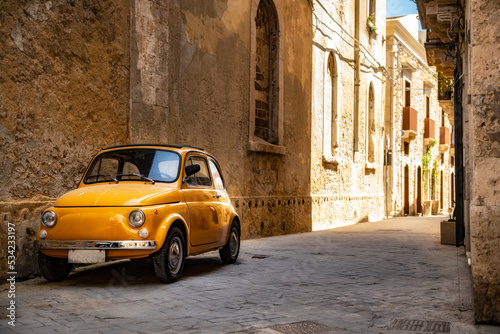 Old yellow Fiat 500 in the city centre of Syracuse in Sicily, Italy © Ron van der Stappen