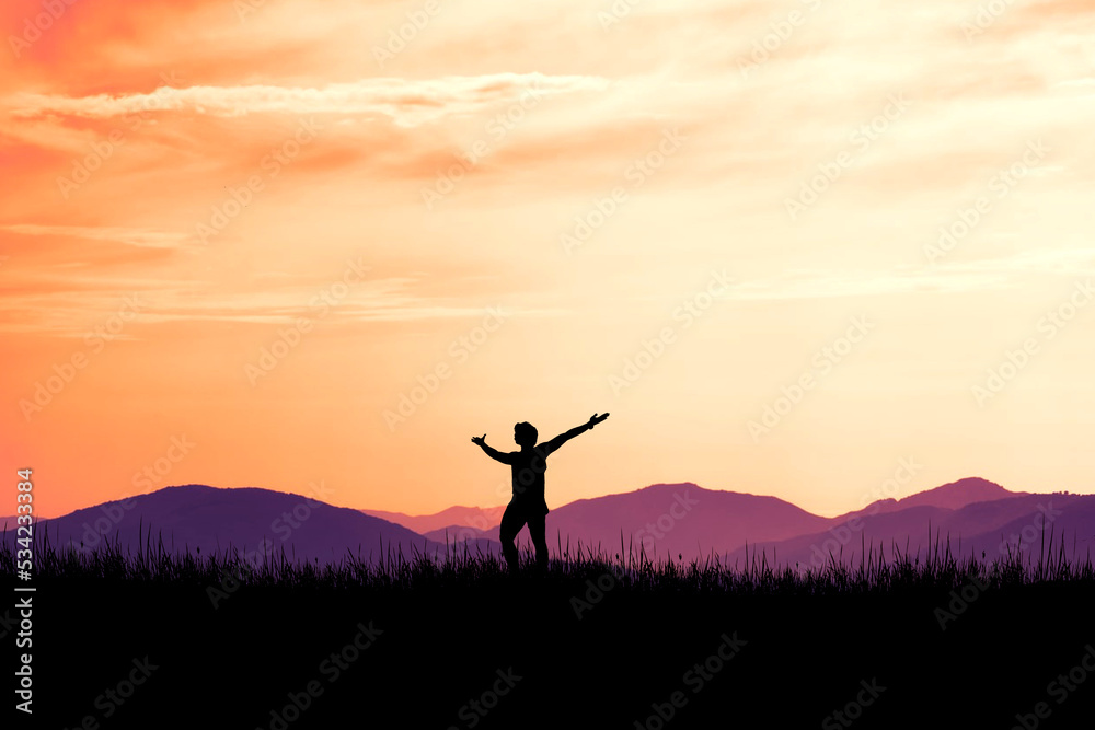 Silhouette of a man standing with his hands up. happily in the meadow