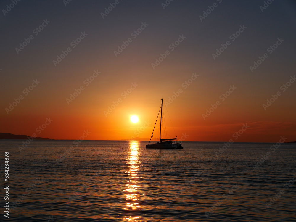 Sunset behind a catamaran in the Aegean Sea 