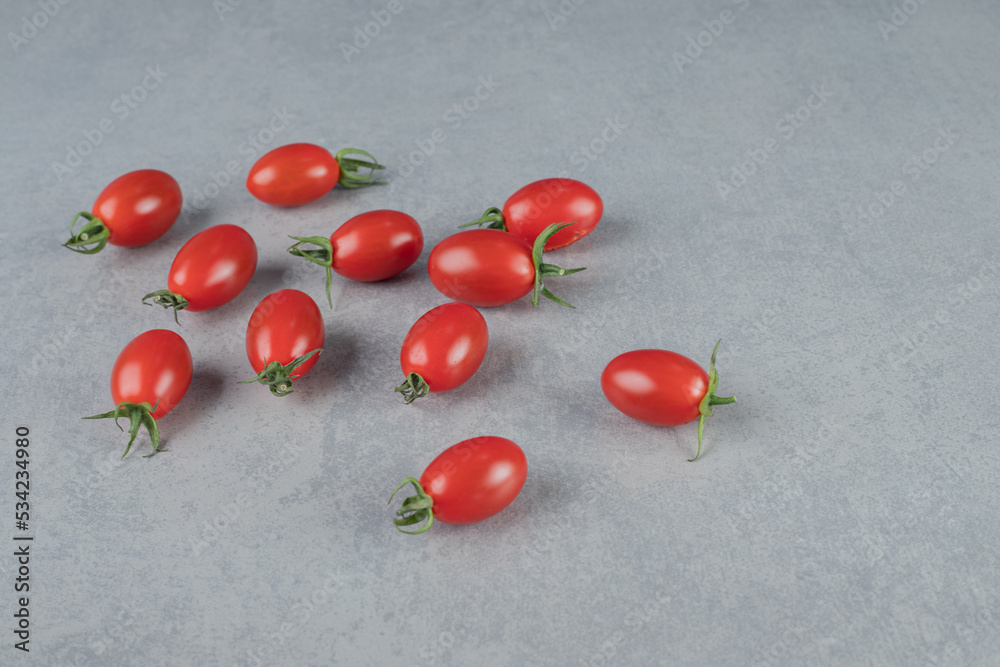Red cherry tomatoes isolated on grey background Red cherry tomatoes isolated on grey background