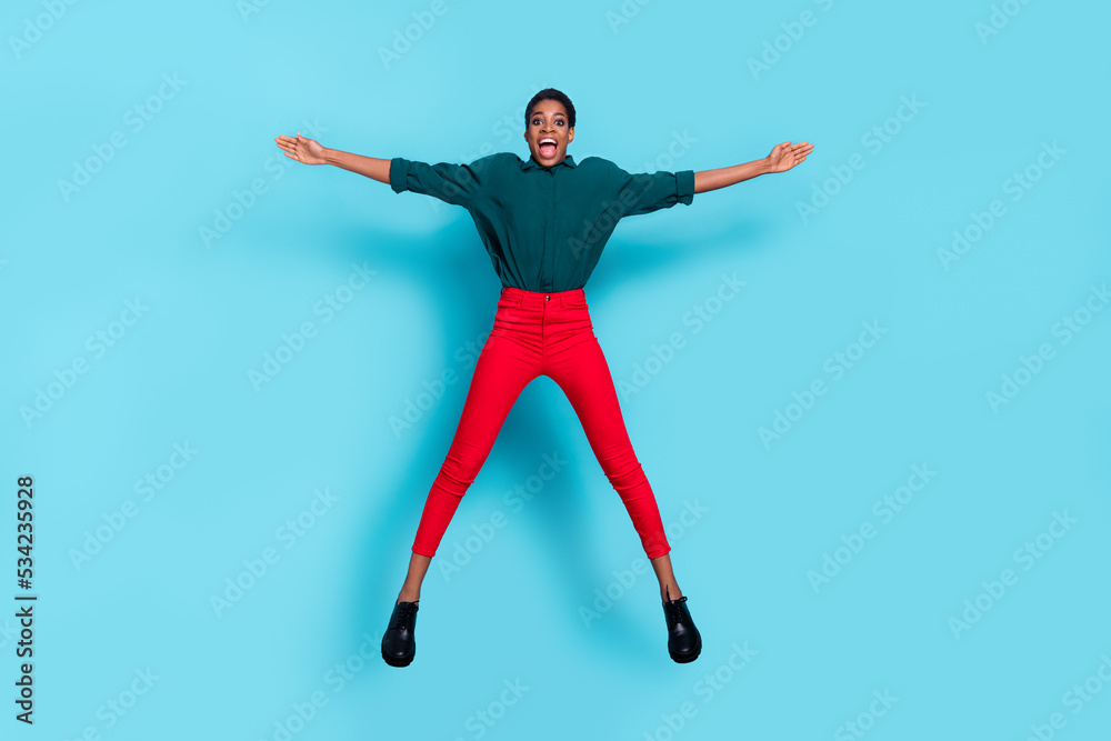 Photo of sweet impressed androgynous human wear green shirt jumping high like star isolated blue color background