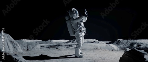 Fotografia Astronaut searching for cellular or wi-fi signal while walking on Moon surface