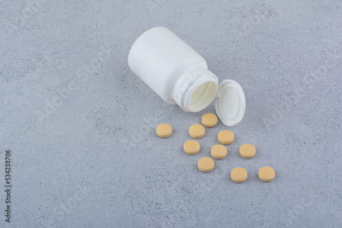 Pharmaceutical pills out of plastic white container