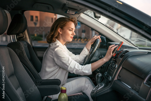 Pensive stylish middle aged business woman driving car using navigation map searching best way. Transportation concept 