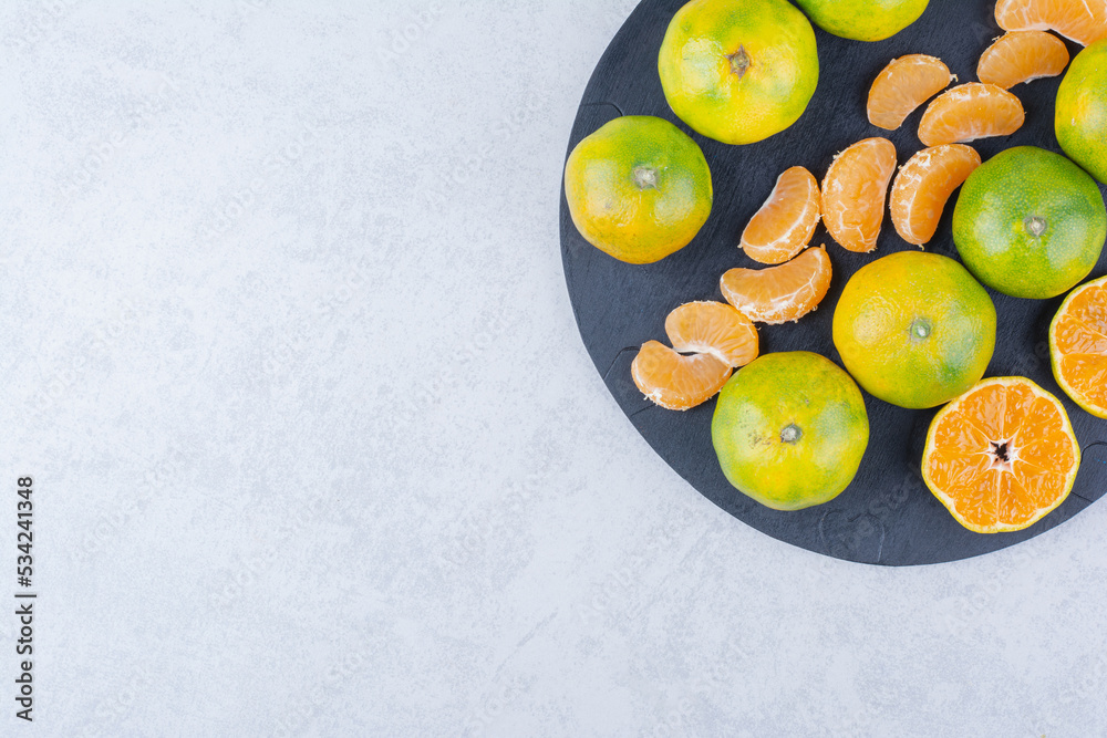 A dark pan of sour tangerines on white background A dark pan of sour tangerines on white background