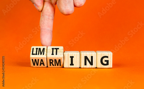 Limiting global warming symbol. Concept words Limiting and Warming on wooden cubes. Businessman hand. Beautiful orange table orange background. Business limiting global warming concept. Copy space. photo