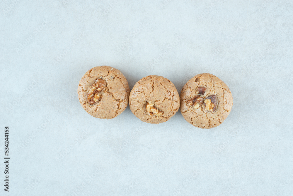 Three sweet round cookies with walnut on white background Three sweet round cookies with walnut on white background