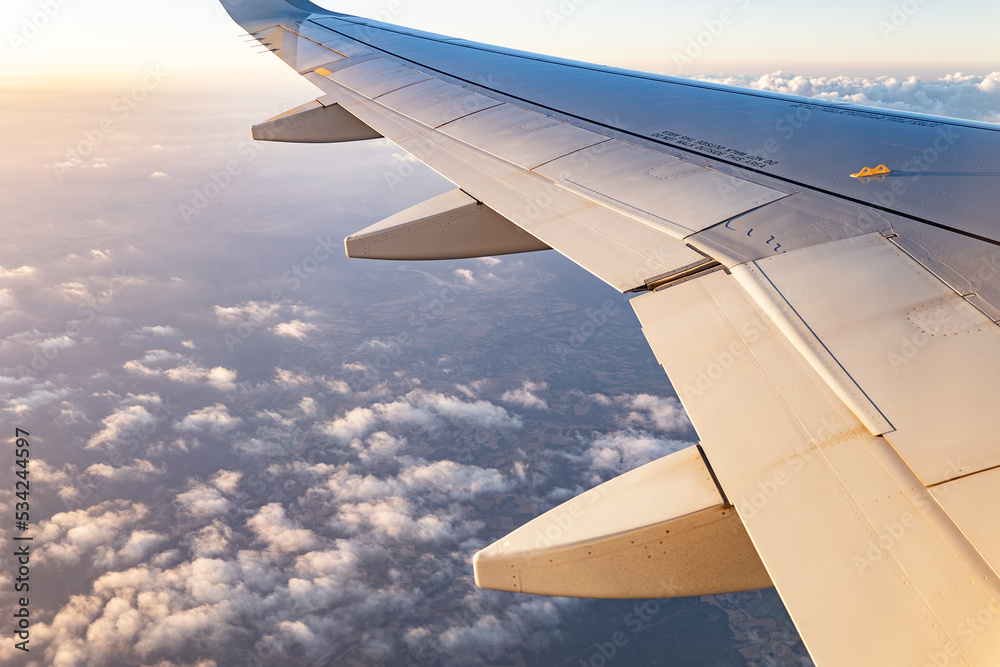 Plane wing in cloudy sky Stock Photo | Adobe Stock