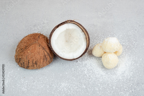 Sliced coconut with round sweet cookies on white background
