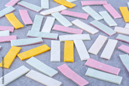 Heap of gum sticks messily scattered over marble background