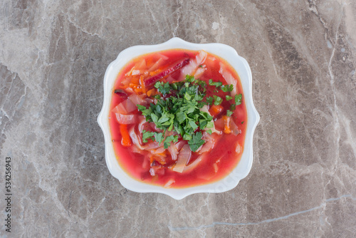 Photo Peppery borsch soup with coriander garnish on marble background