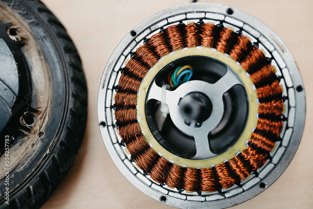 maintenance and repair of the electric motor of the electric scooter.  Electric coil with copper wire. Stock Photo | Adobe Stock