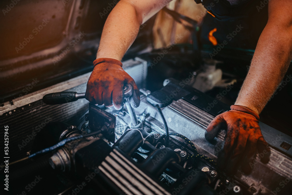 auto mechanic repairs the car, removes the valve cover, unscrews the bolts. auto mechanic repairs the car, removes the valve cover, unscrews the bolts.