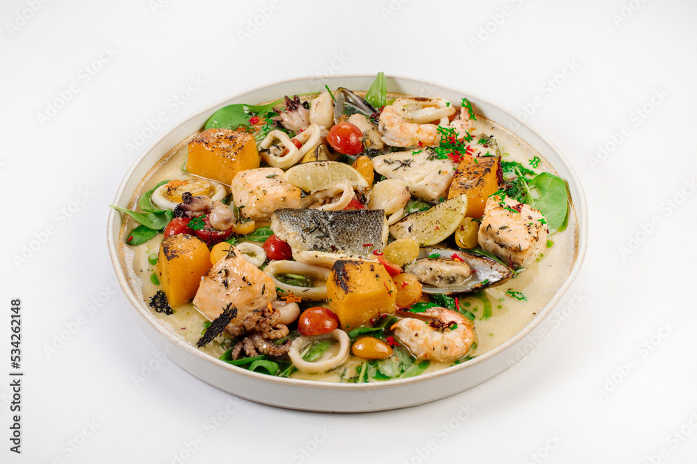 Dish of boiled dorada fish with shellfish, vegetables and herbs Dish of boiled dorada fish with shellfish, vegetables and herbs
