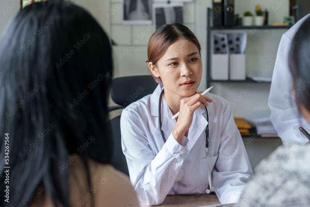 Portrait of a doctor advising clients on health issues holding a tablet to work and talking to patients who come to treatment Portrait of a doctor advising clients on health issues holding a tablet to work and talking to patients who come to treatment