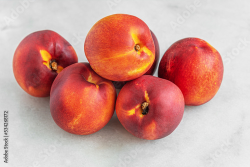 ripe sweet nectarines on a white marble surface