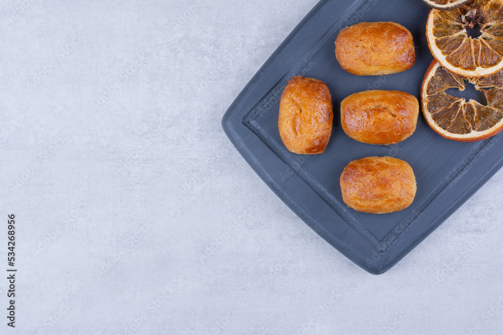 Homemade pastries with dried orange on dark plate