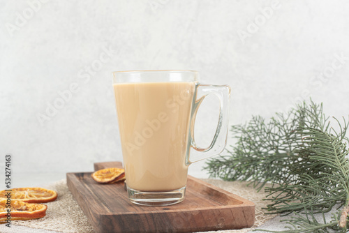 Glass of coffee on wooden board with orange slices