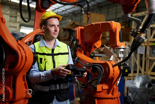 factory worker or engineer operating remote switch controller to control robot machine in the factory © offsuperphoto