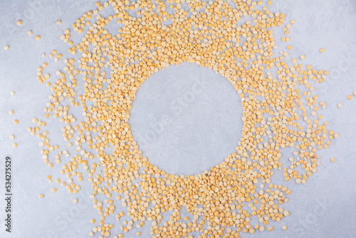 Pile of lentil scattered around  with a circular space in the middle  on marble background