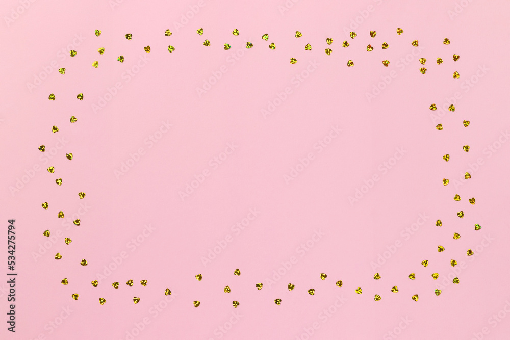 Pink background with golden glitter confetti hearts with copy space
