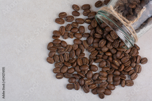 A glass jar of coffee beans on white background