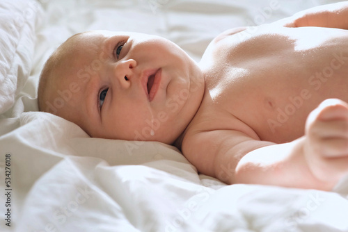 Baby regurgitates breast milk. Little baby with Milk on her Cute Face. Authentic Close Up Footage of Adorable Newborn Baby. Concept of Childhood, New Llife, Breast Feeding, Parenthood. photo