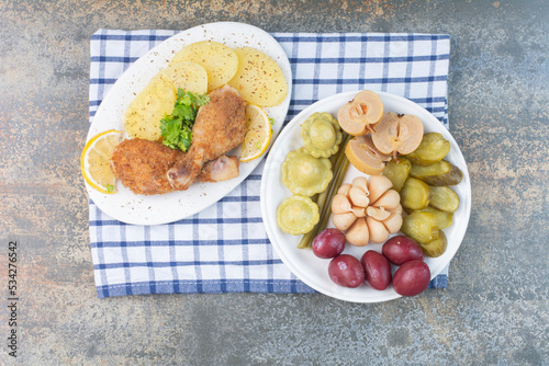 A white plate full of salty vegetables on tablecloth