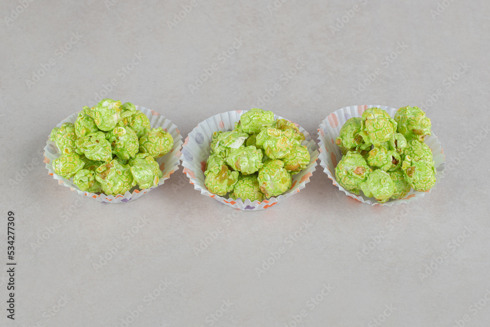 Cupcake cases filled with flavored popcorn portions on marble background Cupcake cases filled with flavored popcorn portions on marble background