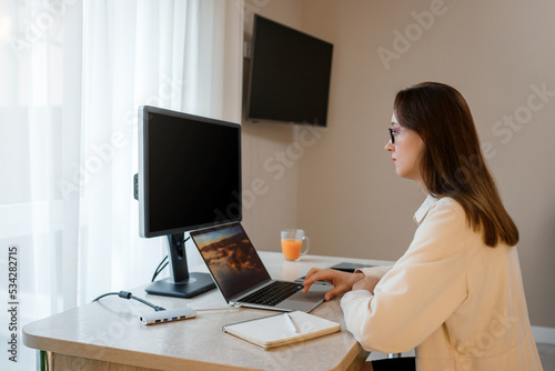 Woman designer working at home office on new ideas. Young happy female freelancer working on project, watching movie on computer, studying, blogging, resting and chatting online