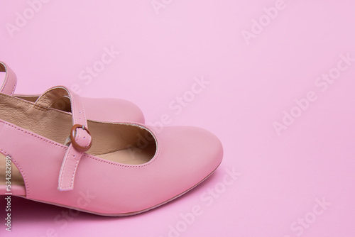 pink women's shoes on a pink background with copy space