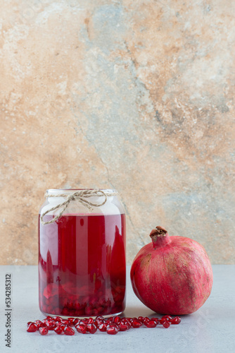 Juice with seeds and pomegranate on blue table photo