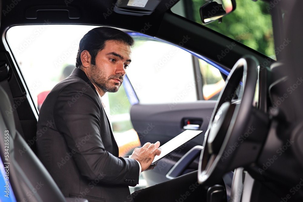 Salesman examine new cars at showroom to deliver to customers. Salesman examine new cars at showroom to deliver to customers.