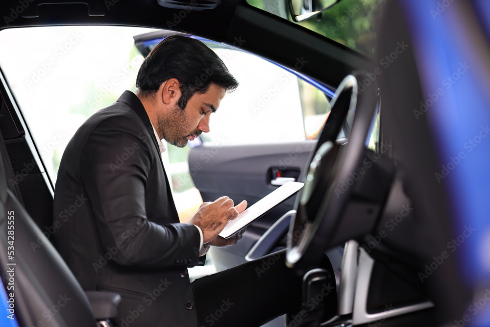 Salesman examine new cars at showroom to deliver to customers.