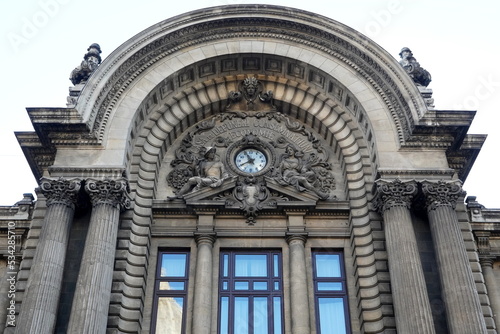 Architectural details of CEC Palace facade on Calea Victoriei boulevard in center of Bucharest. Semicircular pediment with stone sculpture depicting Mercury and Demetra deities
 photo