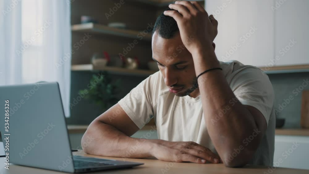 African Latina male man at kitchen at home play online game bet losing betting bad result feel frustrated upset working problems business failure with laptop cryptocurrency crash mistake with computer