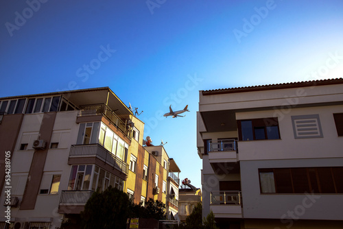 A passenger plane comes in to land over the residential areas of the city of Antalya.
