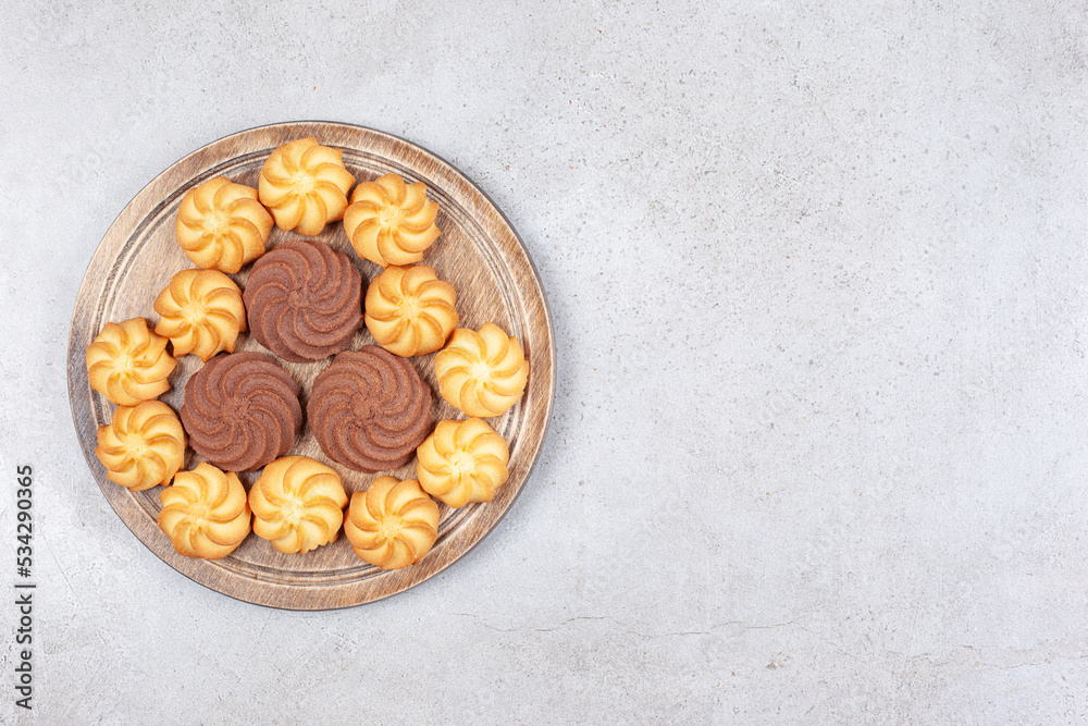 Cookies decoratively aligned on wooden board on marble background Cookies decoratively aligned on wooden board on marble background