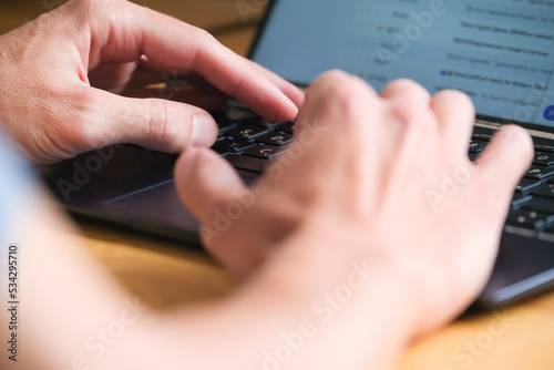 Man types on keyboard of notebook closeup