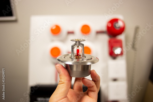 Fire alarm and mock sprinkler system attached to a white wall used for training