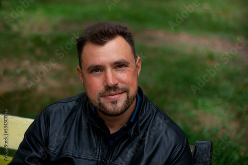 A man with very kind eyes is resting on the street. Pleasant appearance and kind look have a good communication